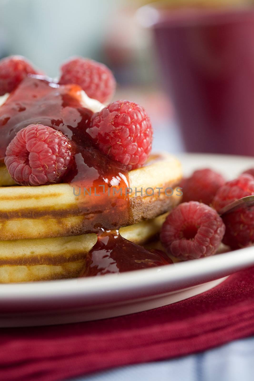 Delicious pancakes with cream and raspberries