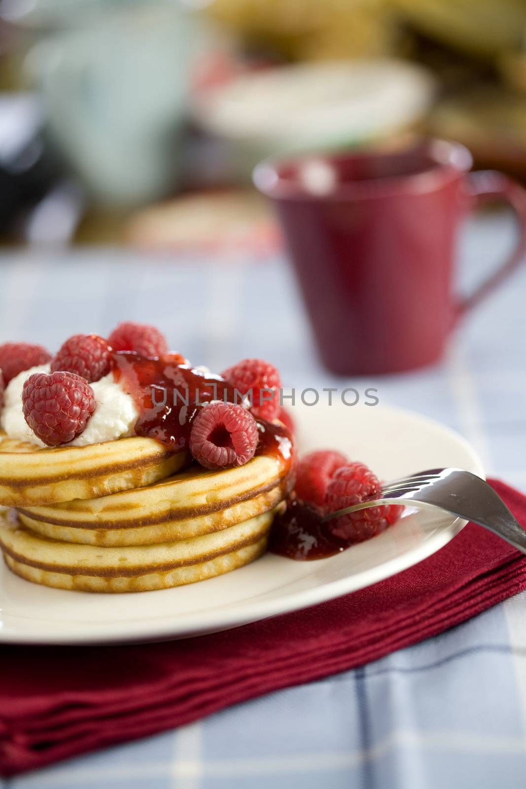 Delicious pancakes topped with ricotta cream and raspberries