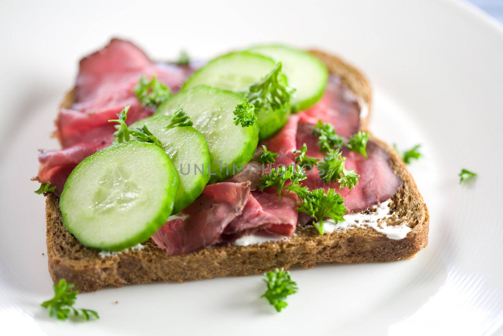 Healthy sandwich with roast beef and cucumber sprinkled with parsley