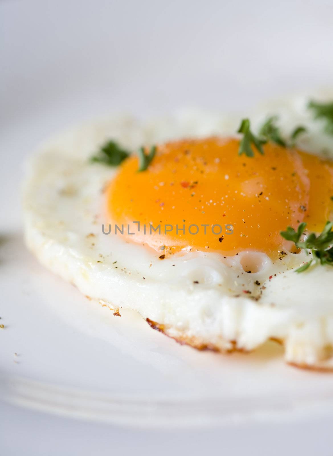 Closeup of a fried egg sprinkled with fresh ground pepper