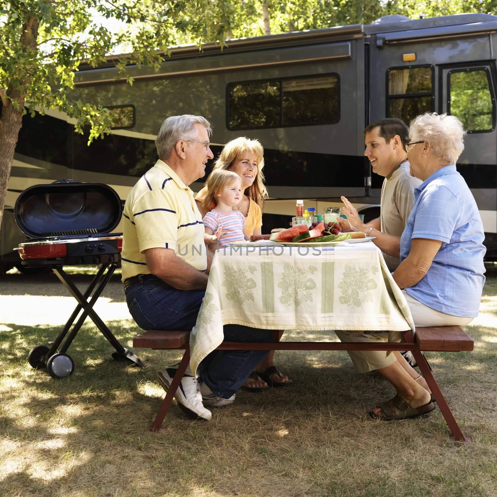 Family at picnic table. by iofoto