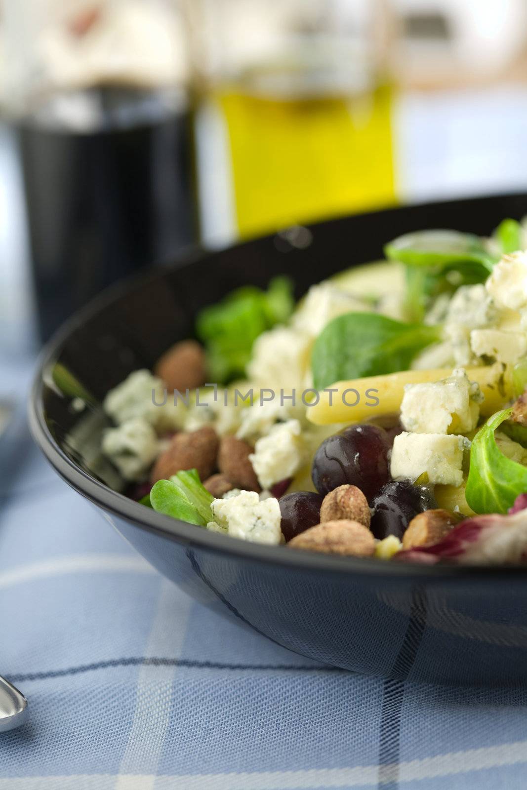 Delicious salad with nuts, fruit, pasta and blue cheese