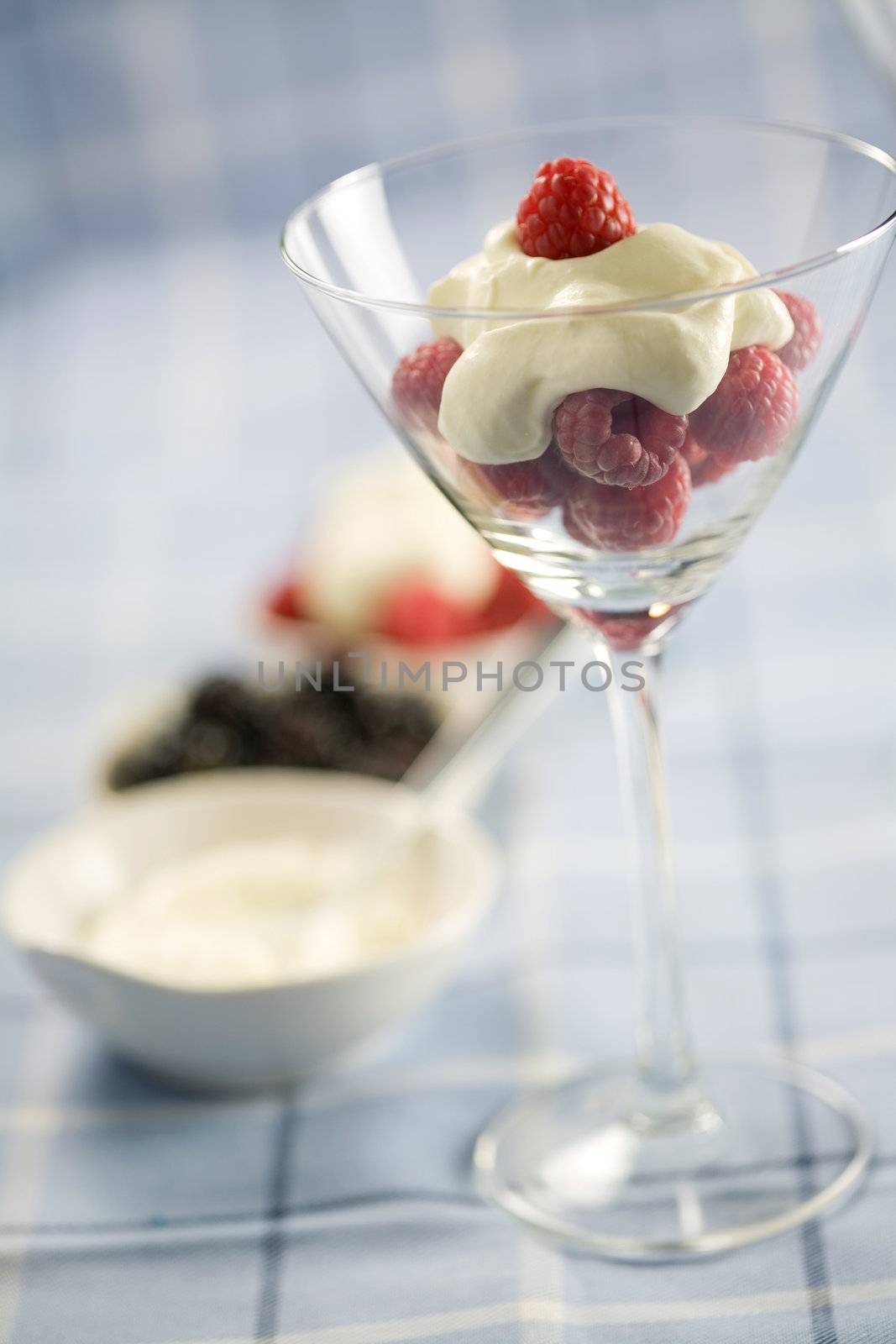 Raspberries with whipped cream in martini glass