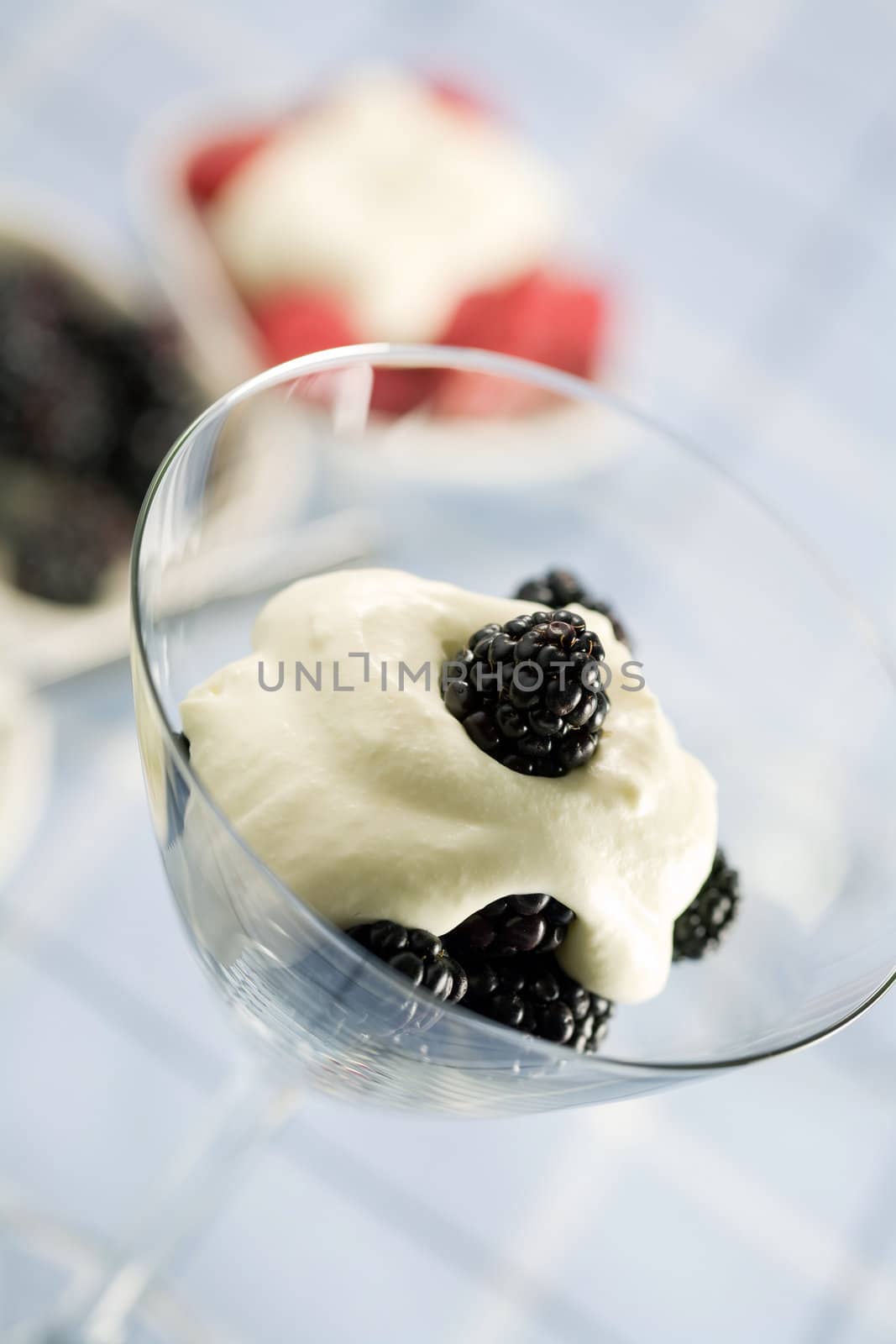 Dessert with blackberries and whipped cream served in a martini glass