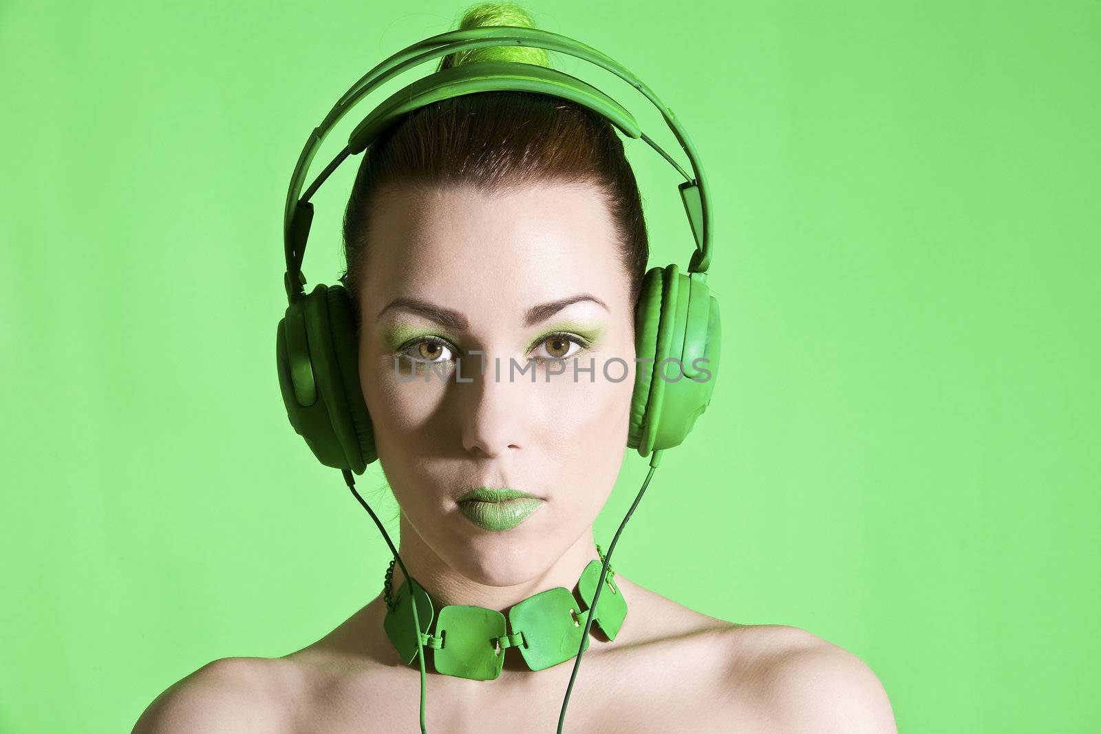 Beautiful brunette with headphone on green background