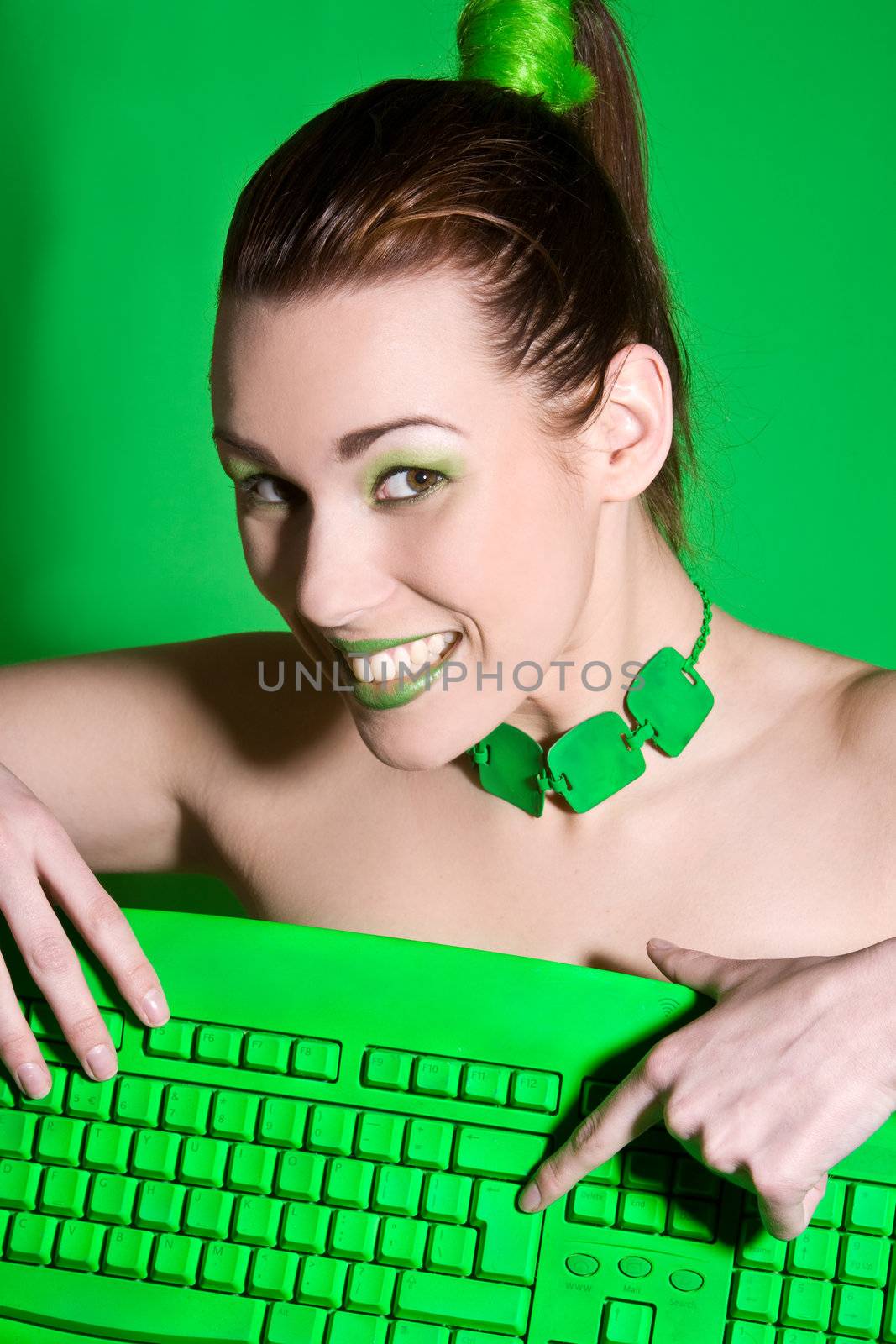 Pretty brunette with cheeky smile hitting the enter key on keyboard