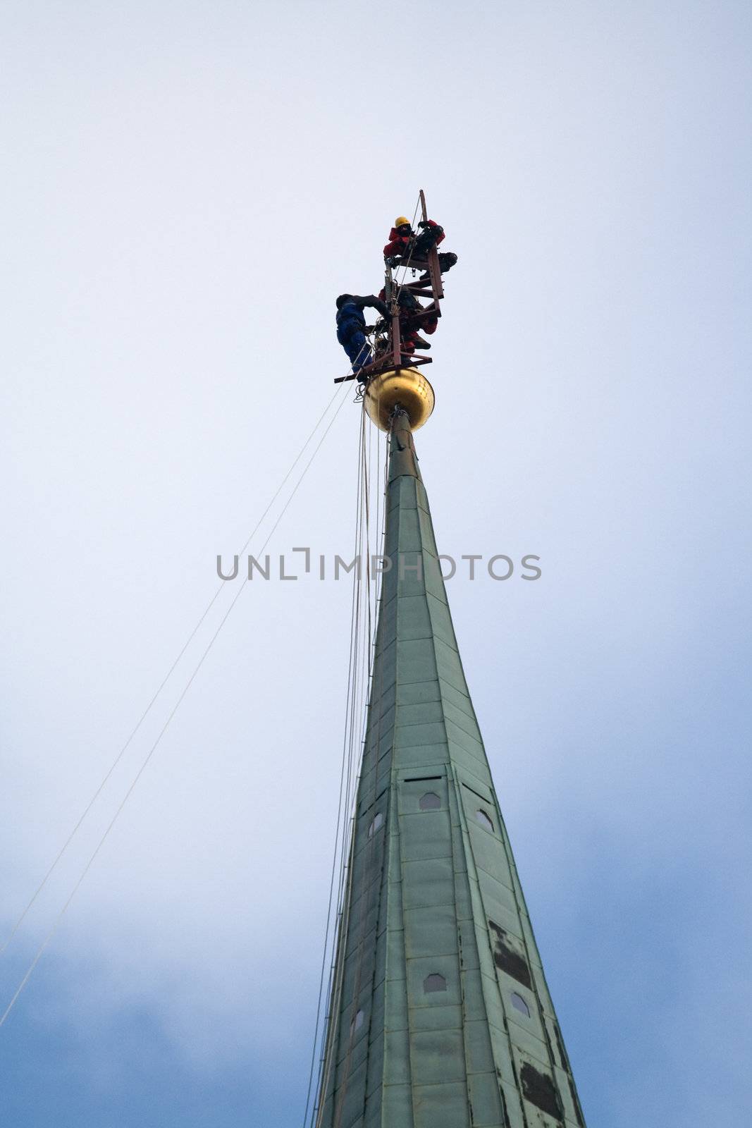 Many Industrial alpinists working at church tower