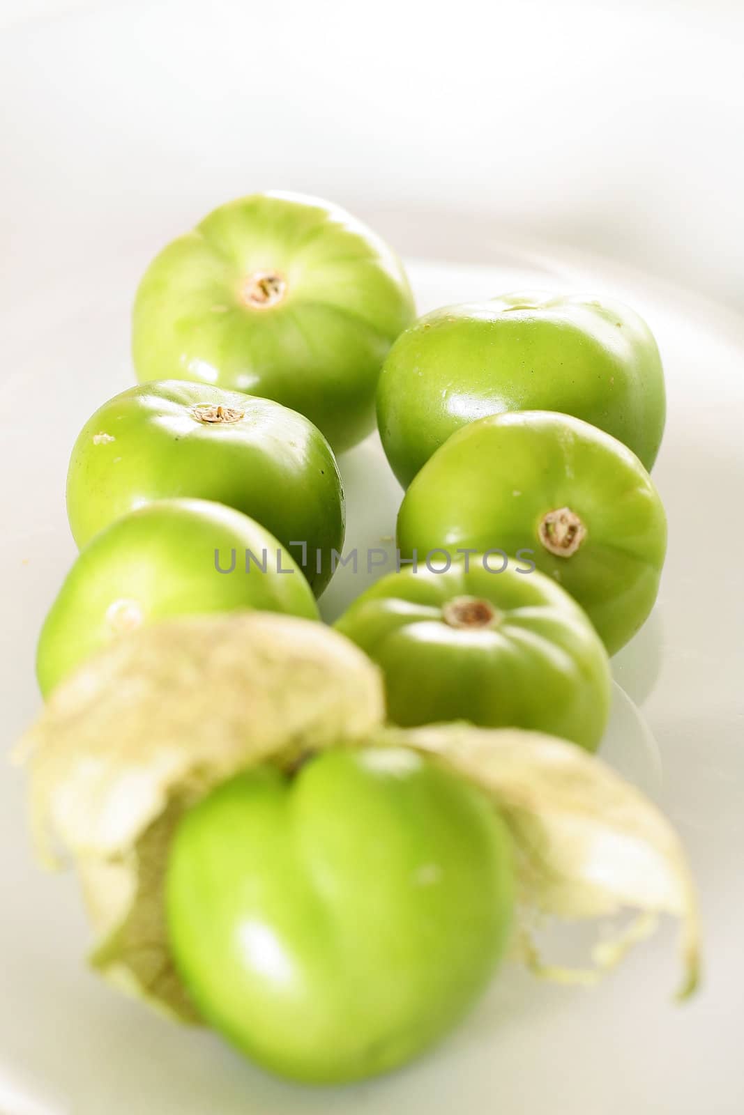 tomatillos on white vertical upclose