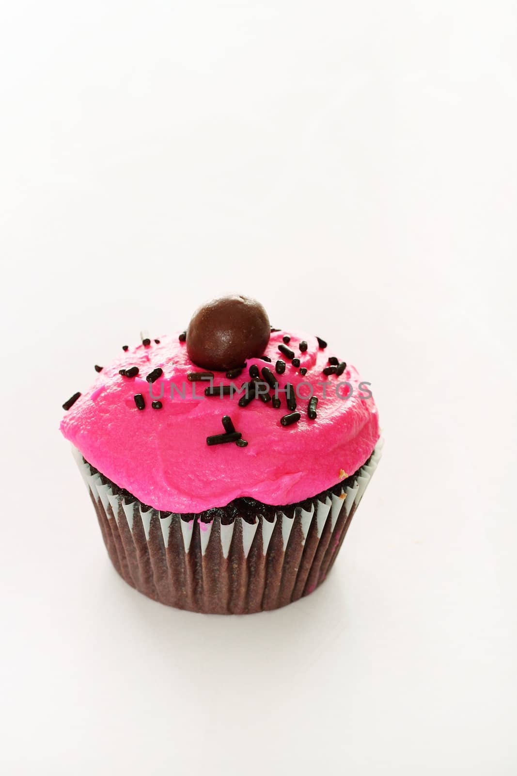 shot of a chocolate cupcake with pink frosting by creativestock