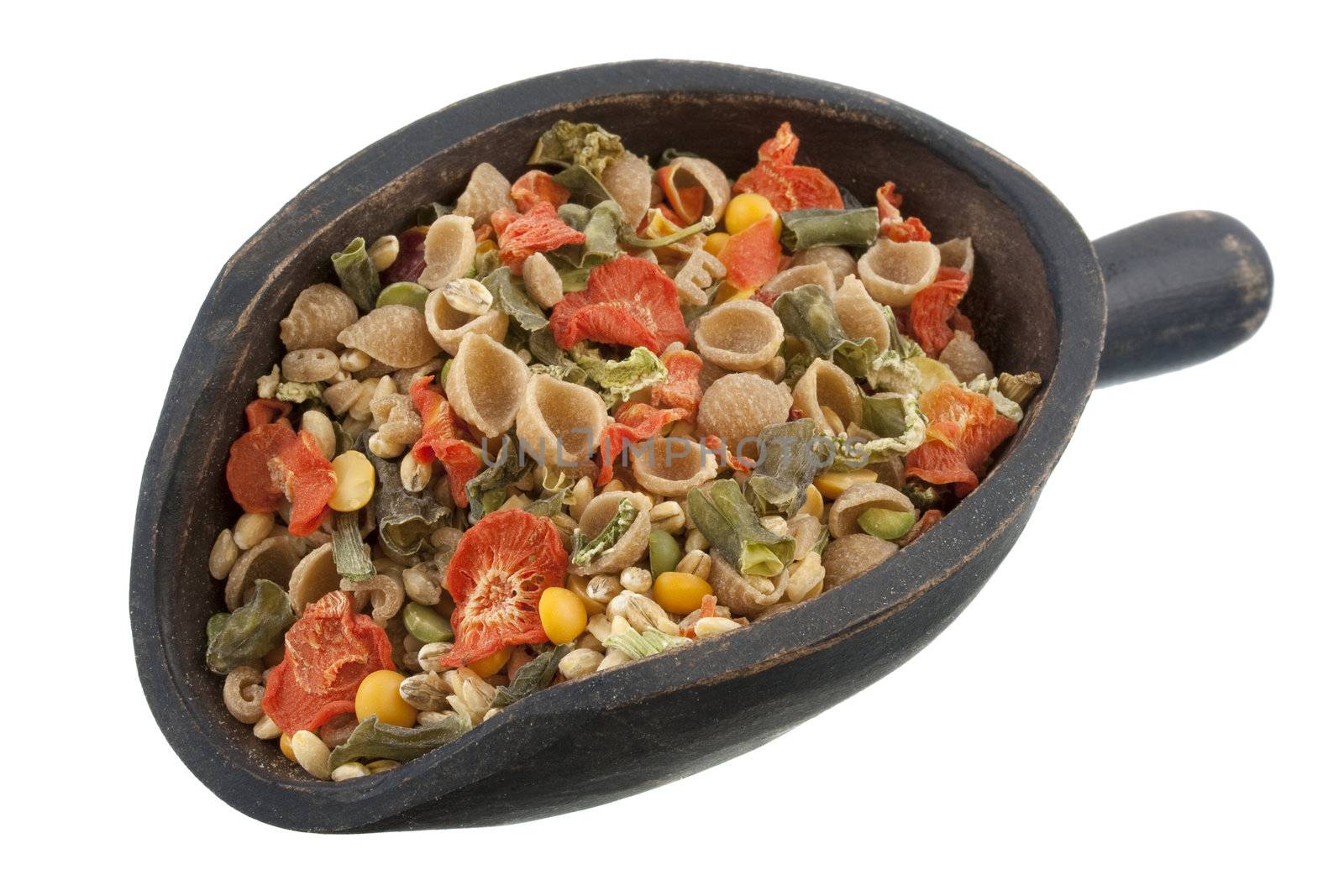a rustic, wooden scoop of vegetable soup mix including whole wheat pasta, carrots, peas, leeks, green beans, bell peppers, corn, celery and onions, isolated on white