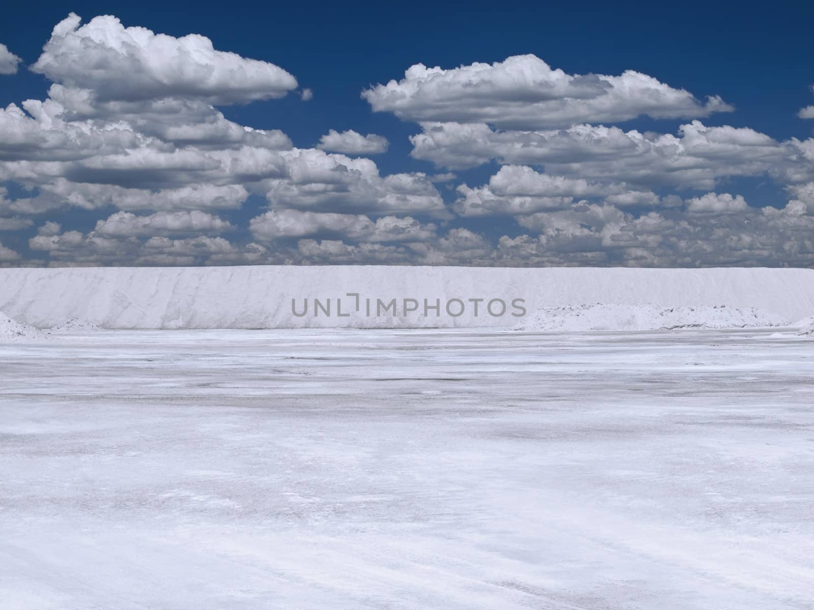 Large open salt mine under a bright blue sky.