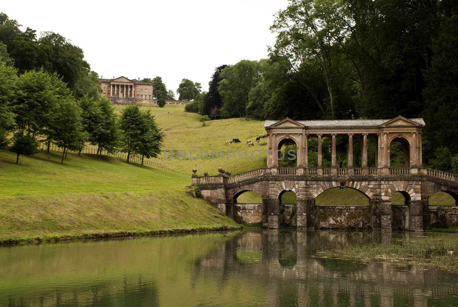 An old bridge with a mansion in the background