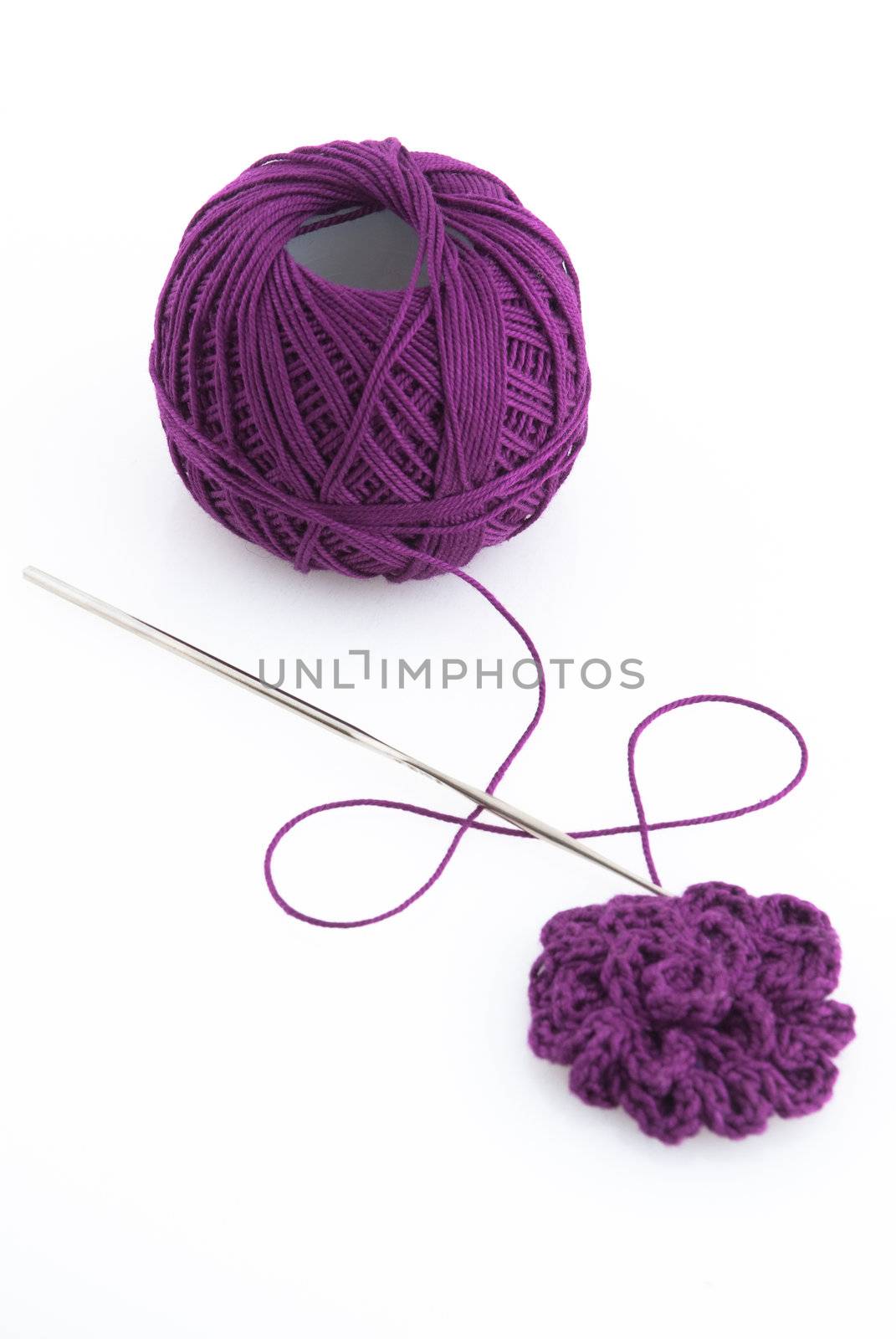 Purple spool and needle on a white background.