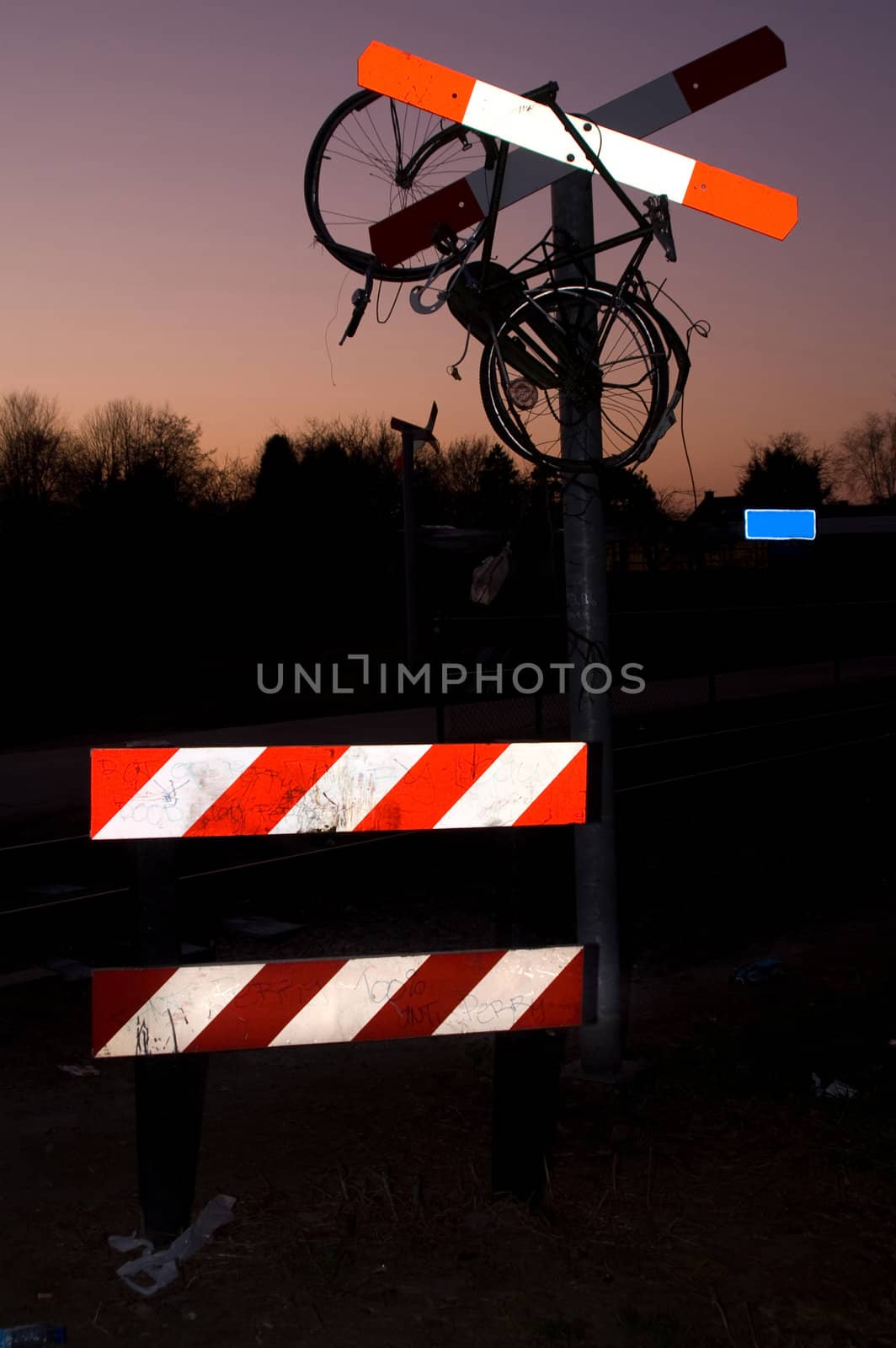 hanging old bike in a railroad crossing sign
