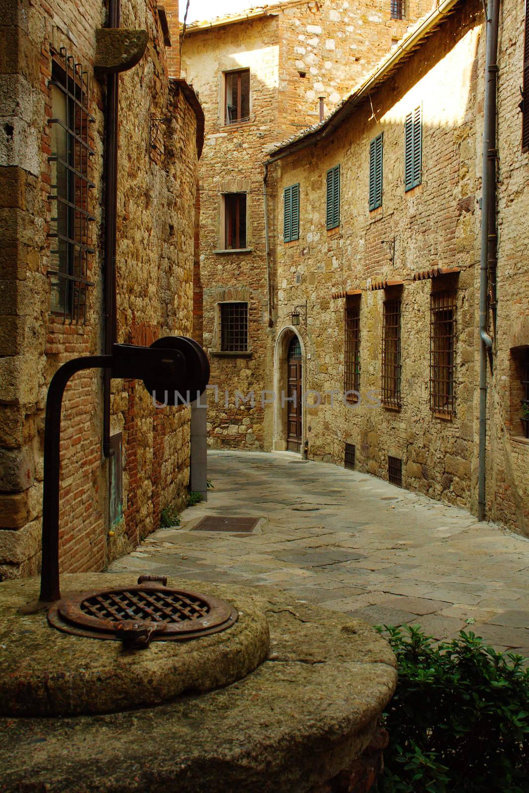 Street of Montepulciano village with a pit in the foreground in Tuscany, Italy