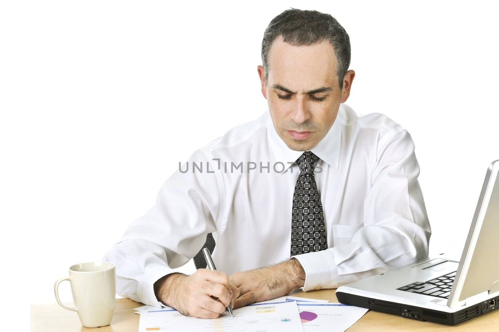 Serious office worker reviewing generic reports at his desk
