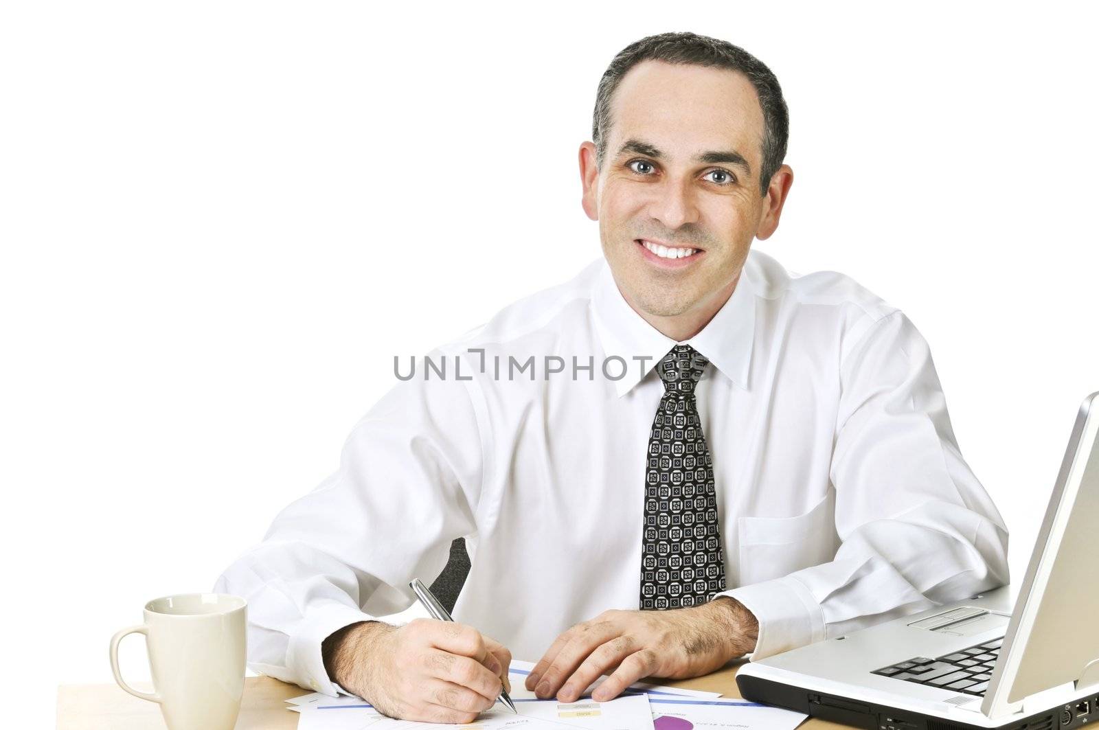 Happy office worker reviewing generic reports at his desk