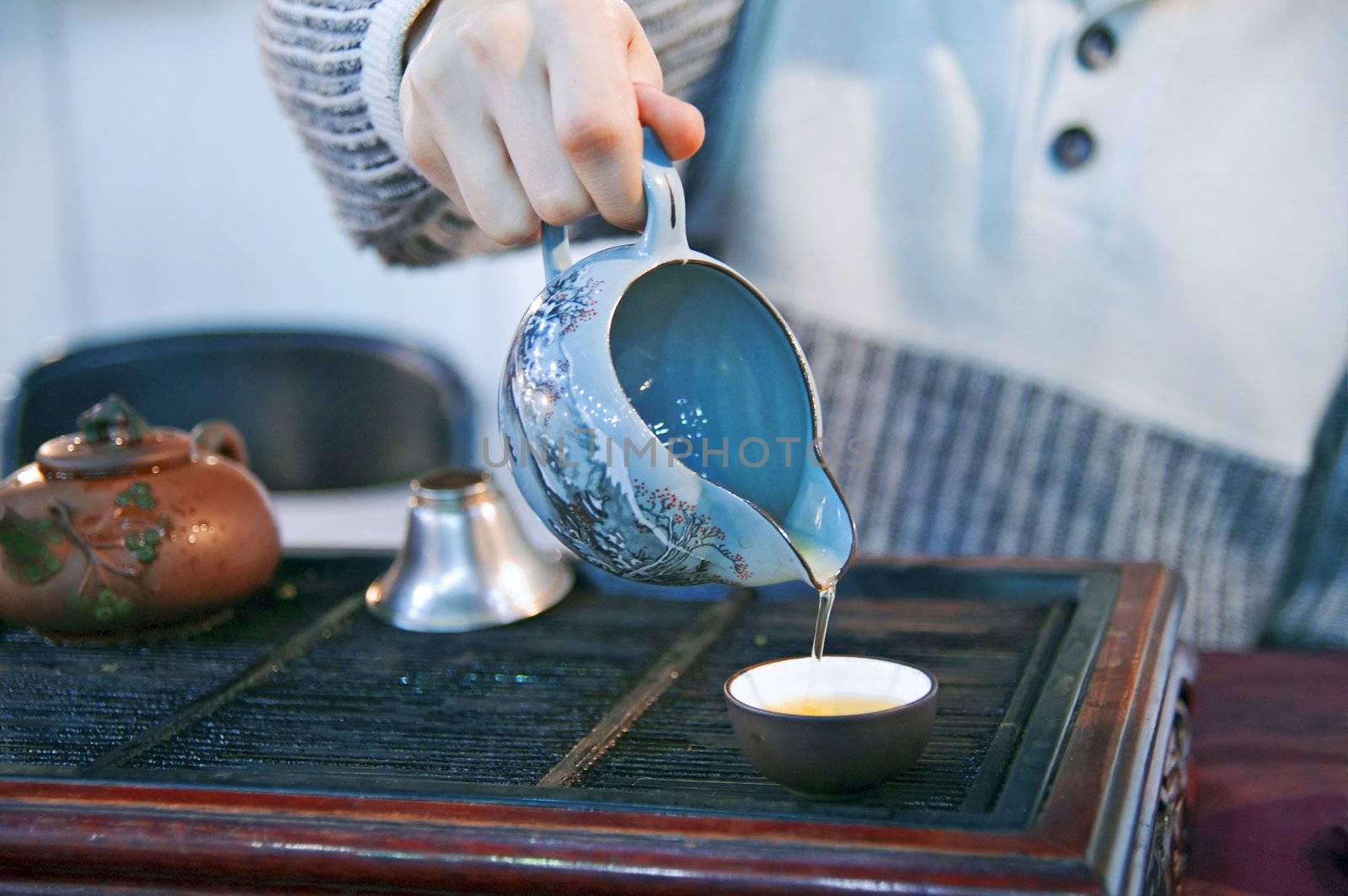 Man pouring green tea to traditional japanese cups