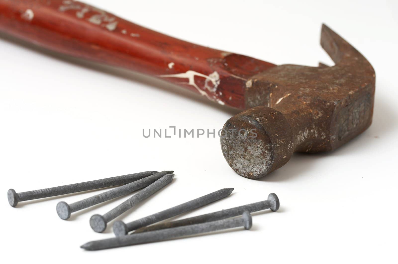 a macro picture of a hammer and nails on white