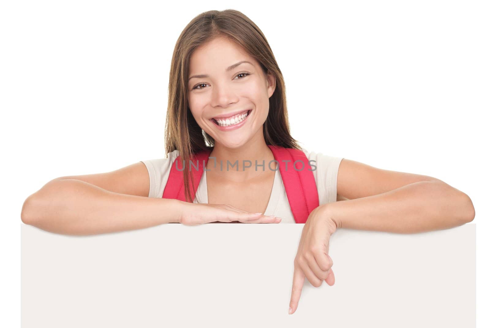 Female university / college student standing above blank empty billboard sign isolated on white background. Young Asian / Caucasian woman student.