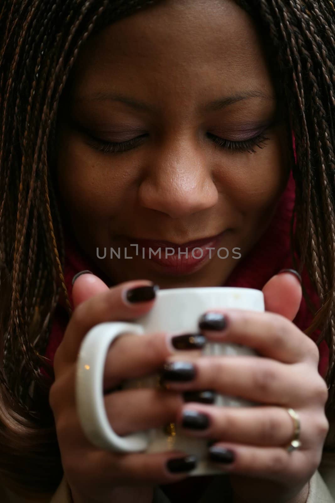 close-up portrait of the beautiful black woman with white mug in hand. small depth to sharpness