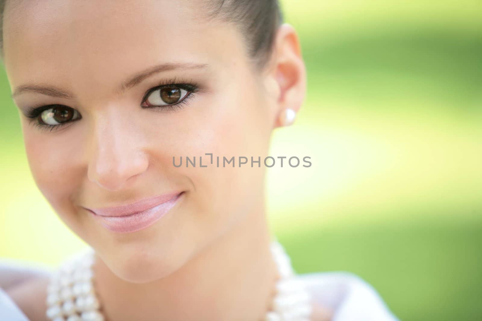 close-up portrait of the charming pretty girl with mother-of-pearl pomade on green background