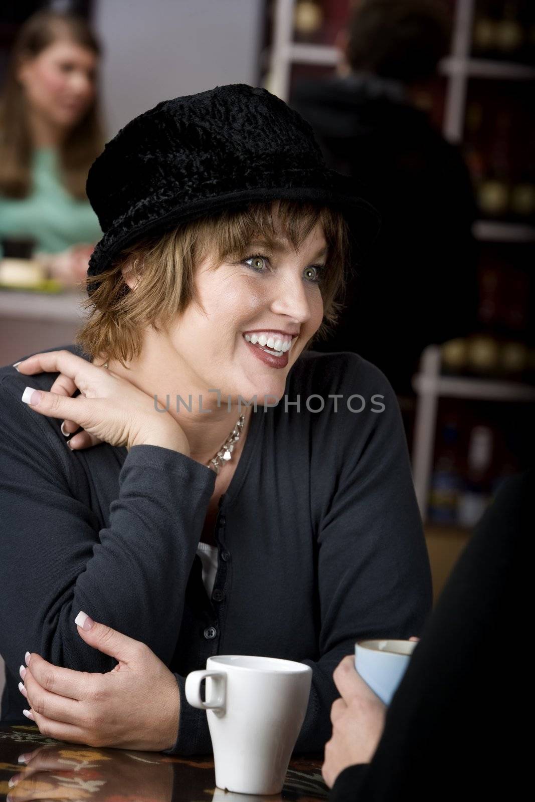 Pretty adult woman with friend in a coffee house