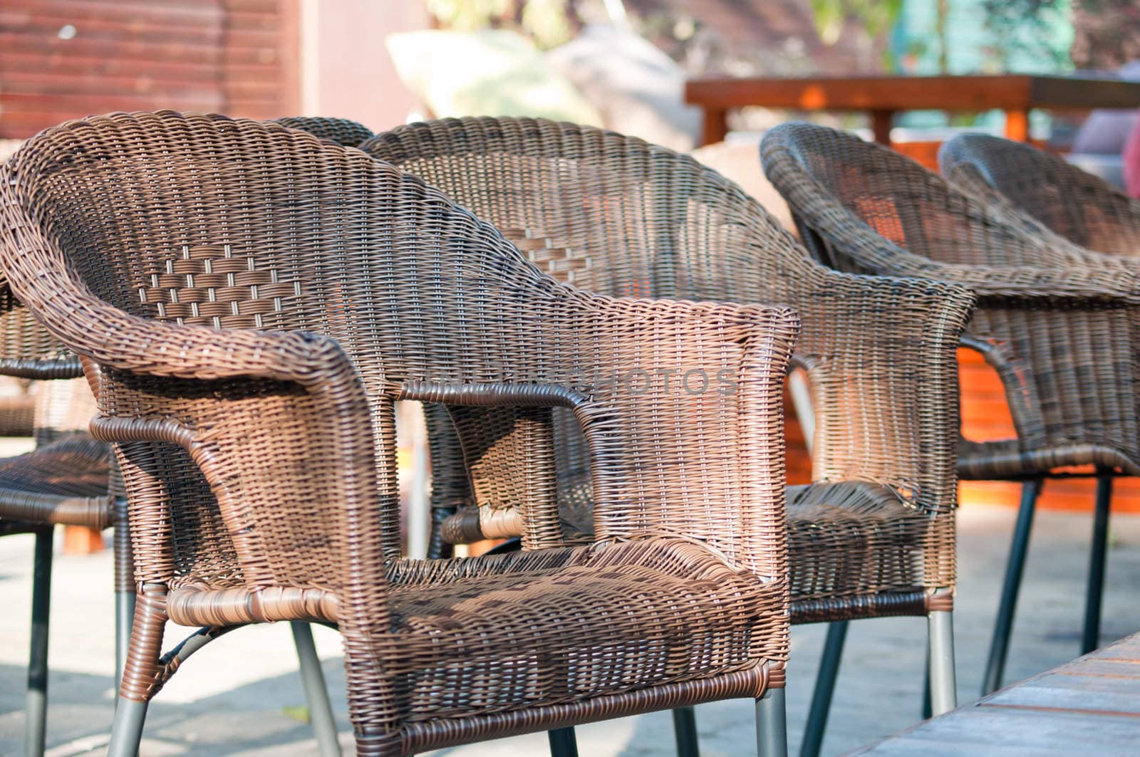 Wicker chairs are on the veranda of the summer cafe.