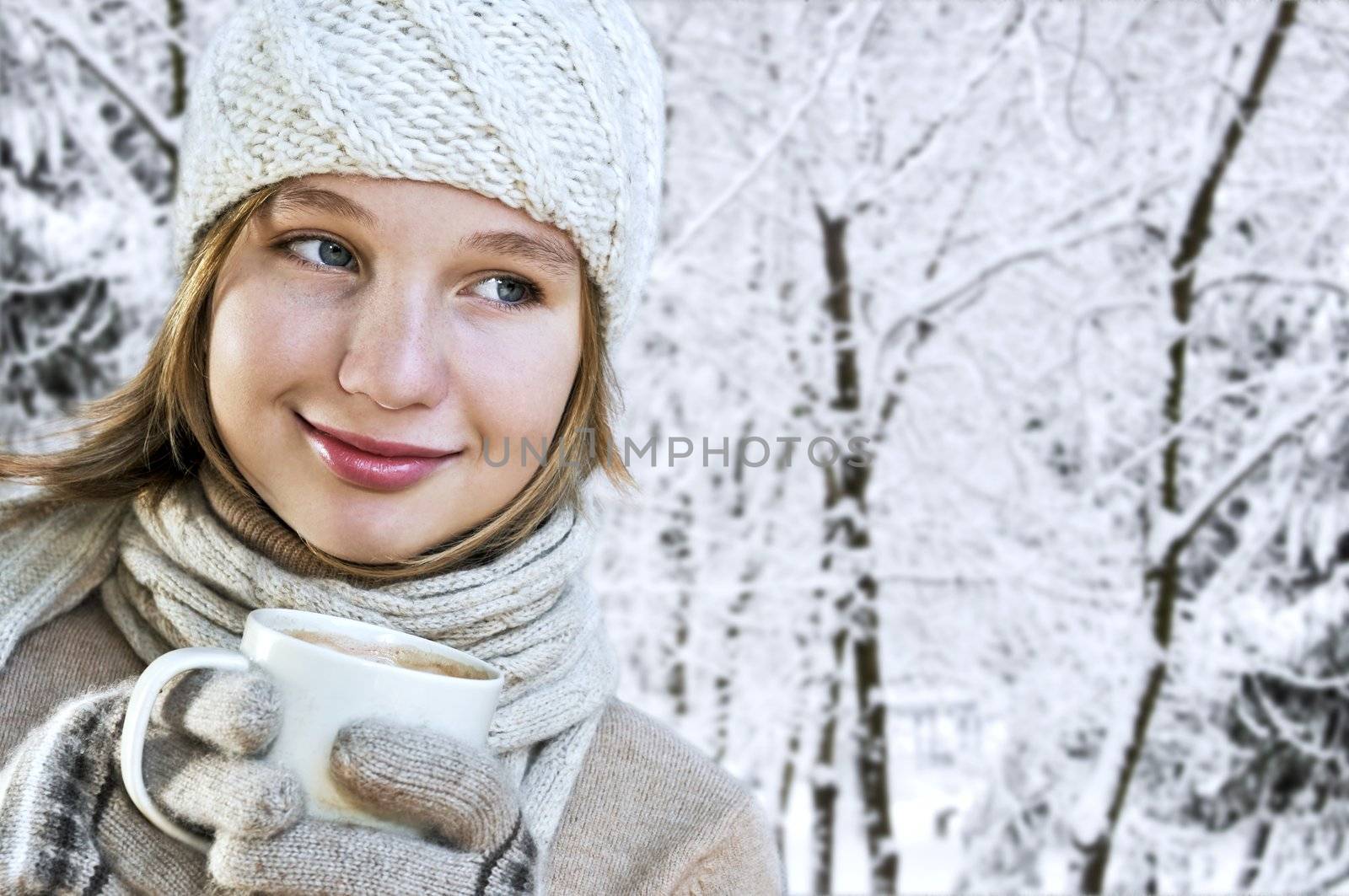 Teenage girl in winter hat with cup of hot chocolate