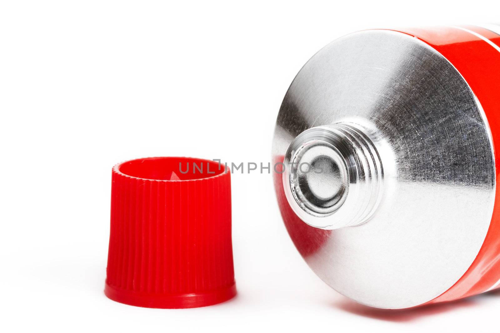one red closed tomato tube on white background