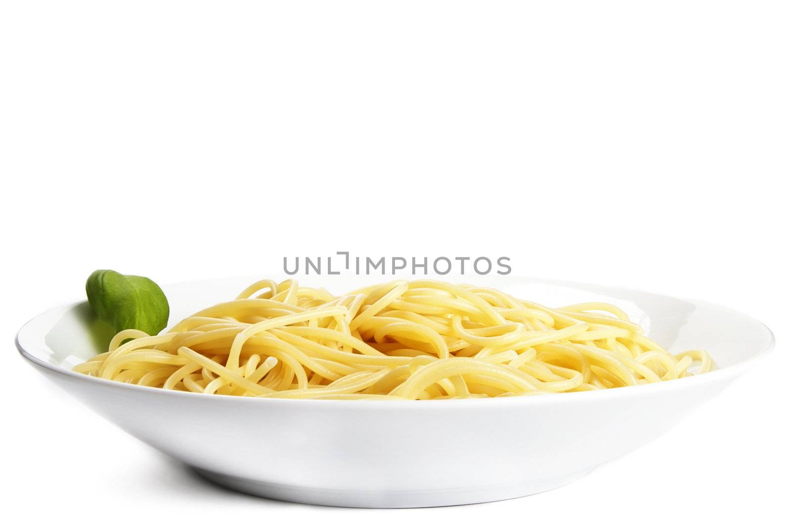 some pasta on a plate with basil on white background