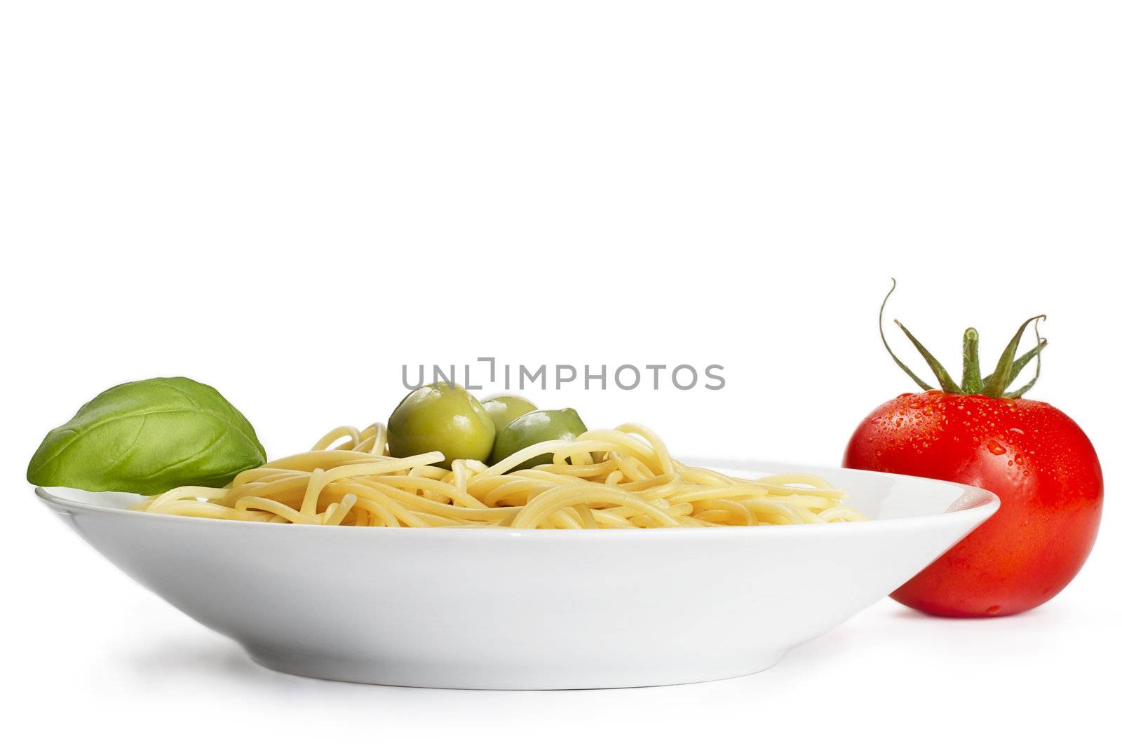 one plate with pasta some olives one tomato and basil