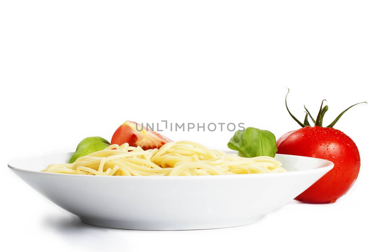 spaghetti in a plate with tomato and basil
