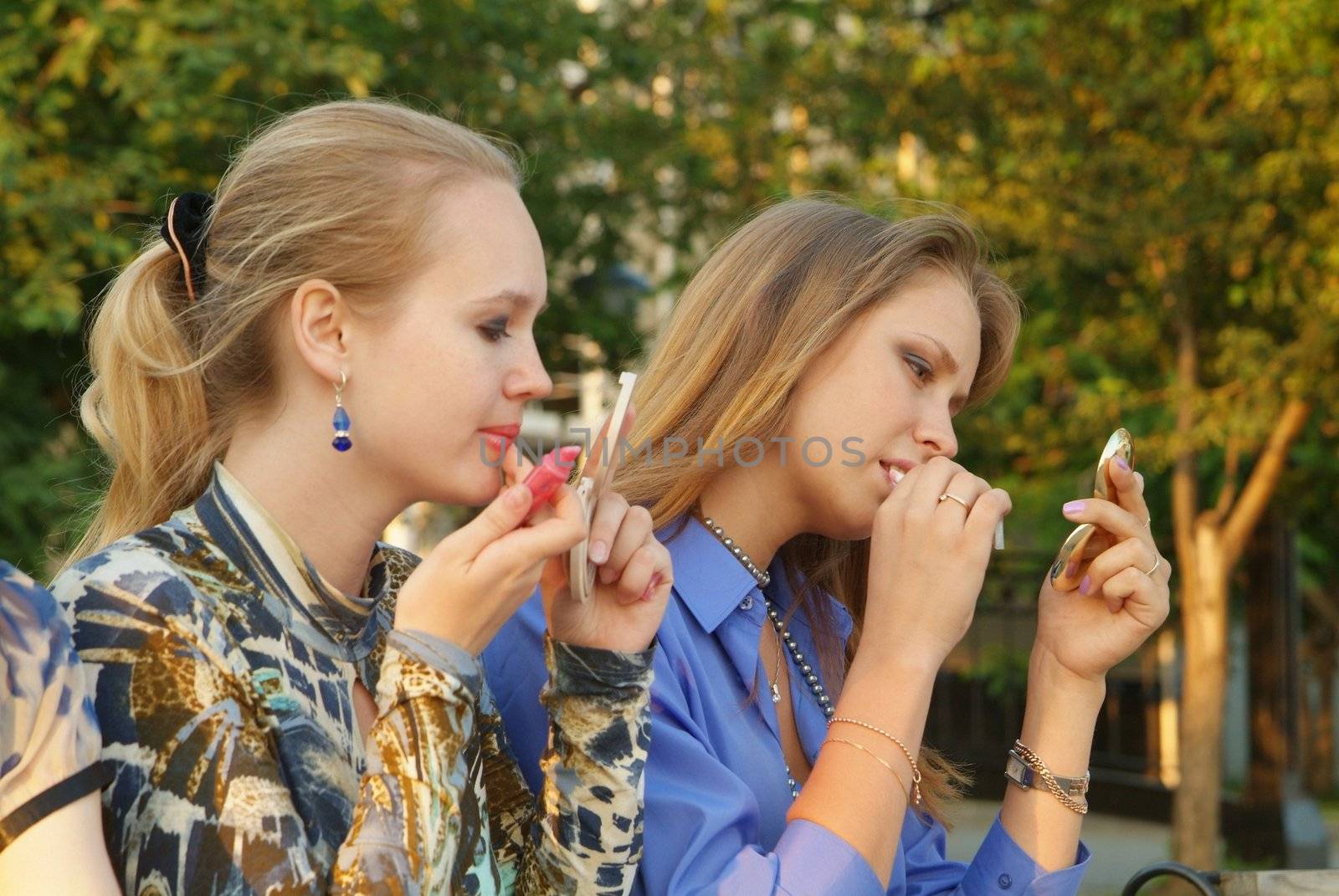 Girls use lipstick outdoor by palomnik