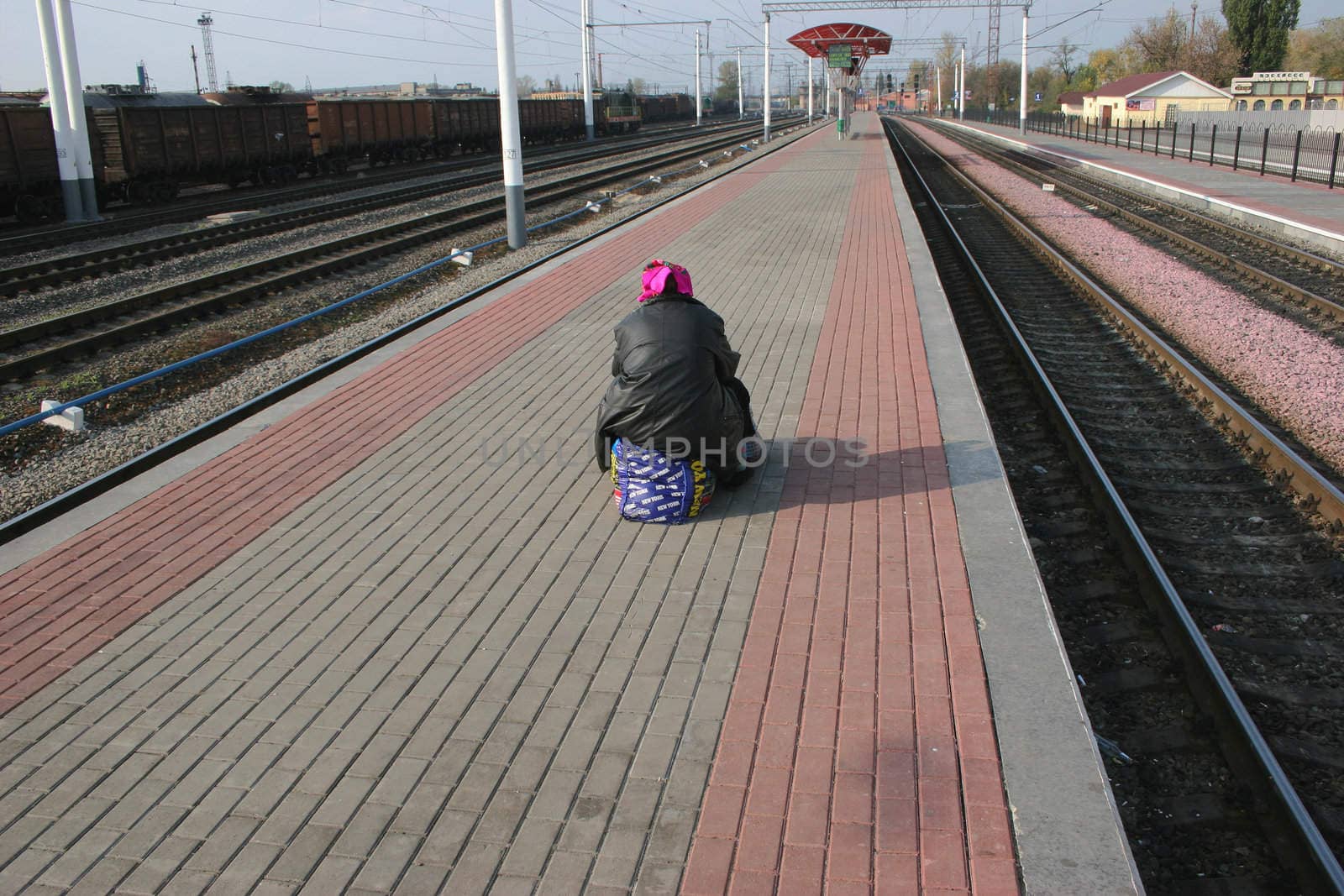 The lonely passenger on a railway platform expecting a train at station the Osnova  Kharkov 15.10.2008 