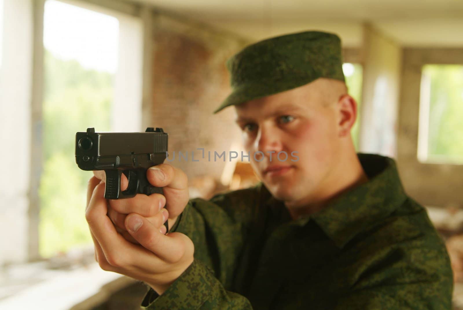 The soldier aims from a pistol.