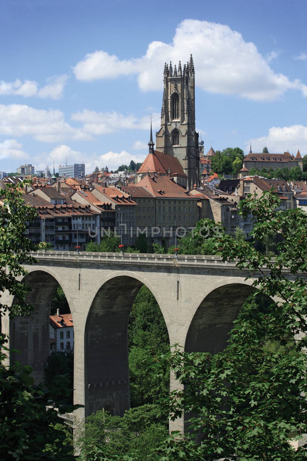 Photo of the bridge and church tower from the city of Fribourg in Switzerland.