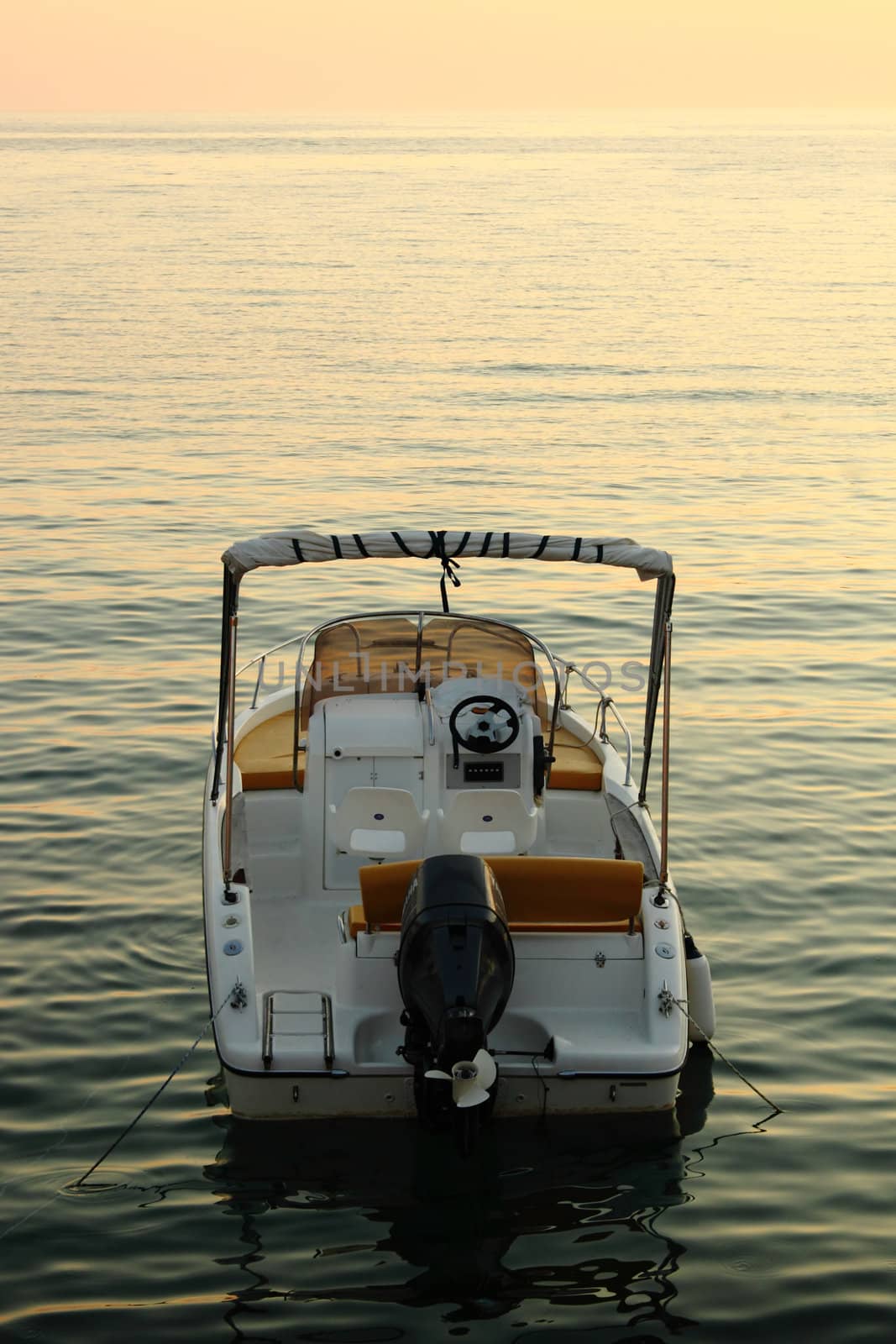 backside of small motorized boat with sunset