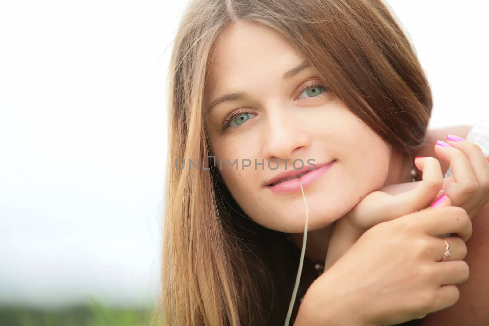 close-up portrait of the beautiful girl with blade of grass in mouth and with copy-space