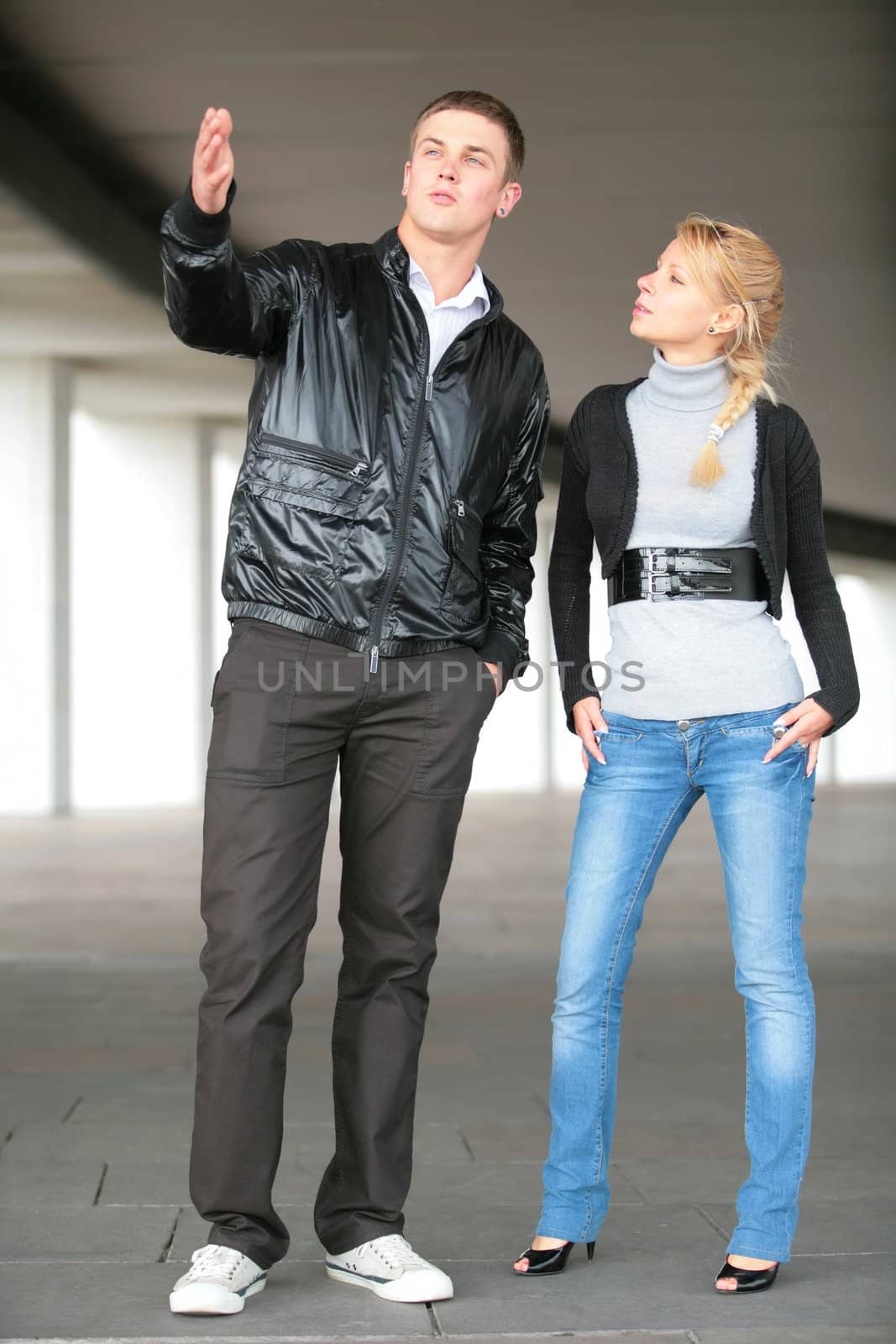 young man in black jacket and girl in blue jeans