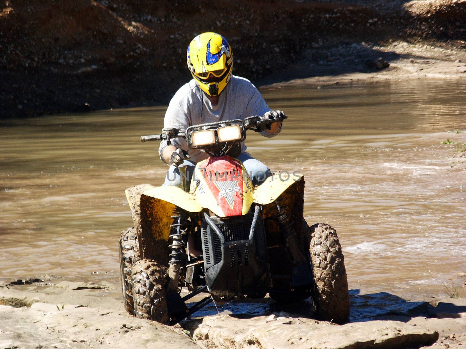 A shot of a young man running some muddy trails on his ATV.