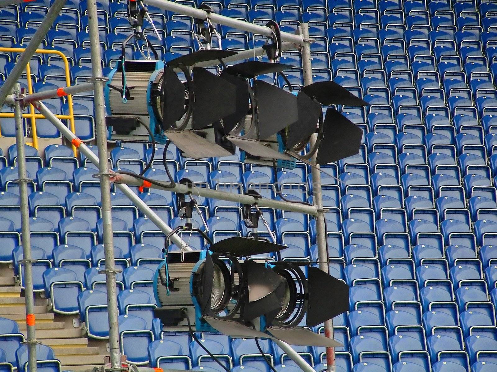 Image of five electric lighting devices on sports arena.