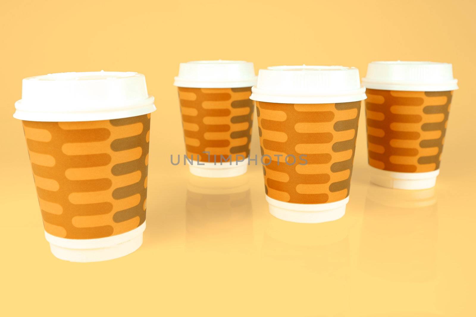 Takeaway coffee cups isolated against an orange background