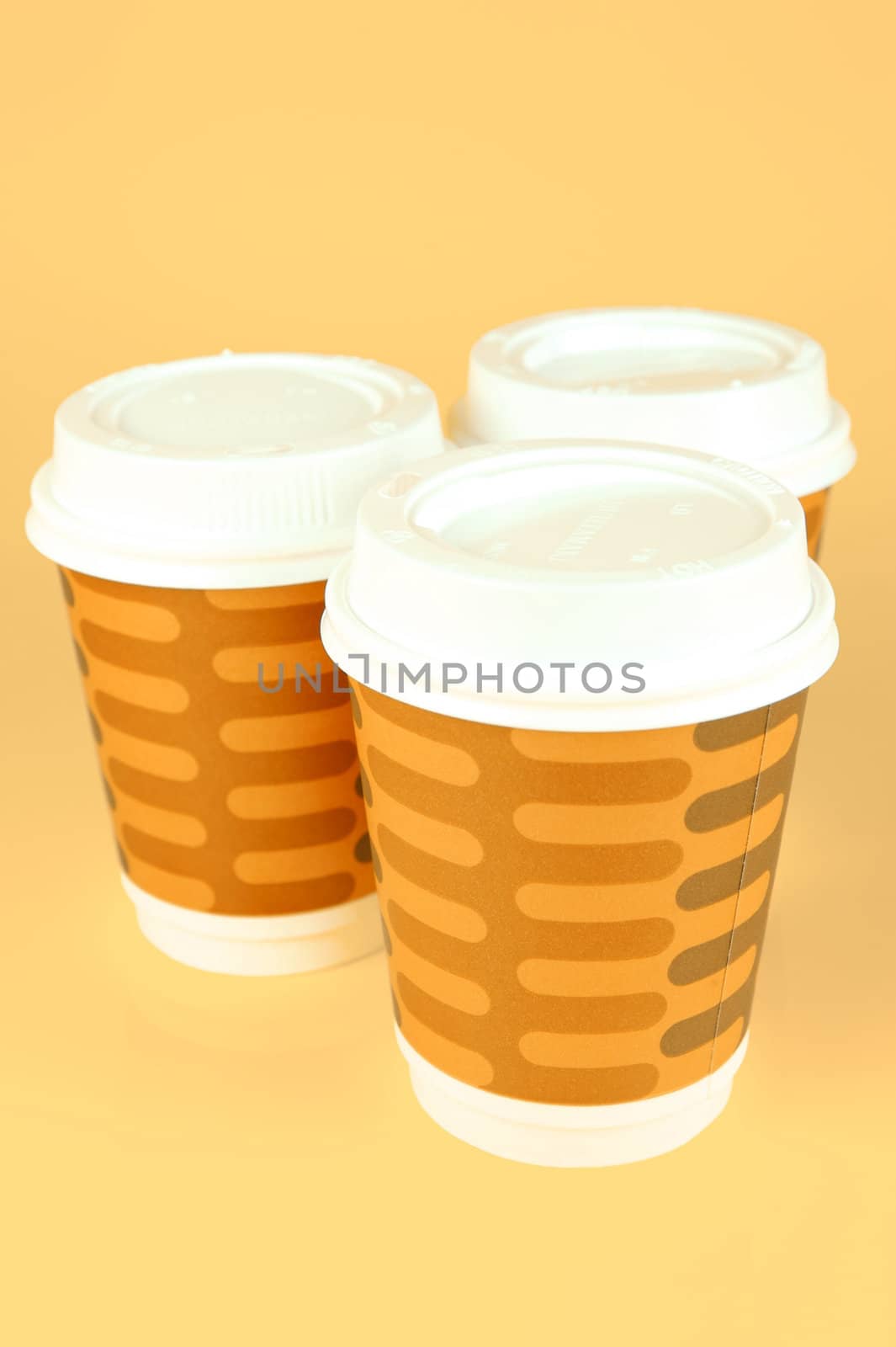 Takeaway coffee cups isolated against an orange background