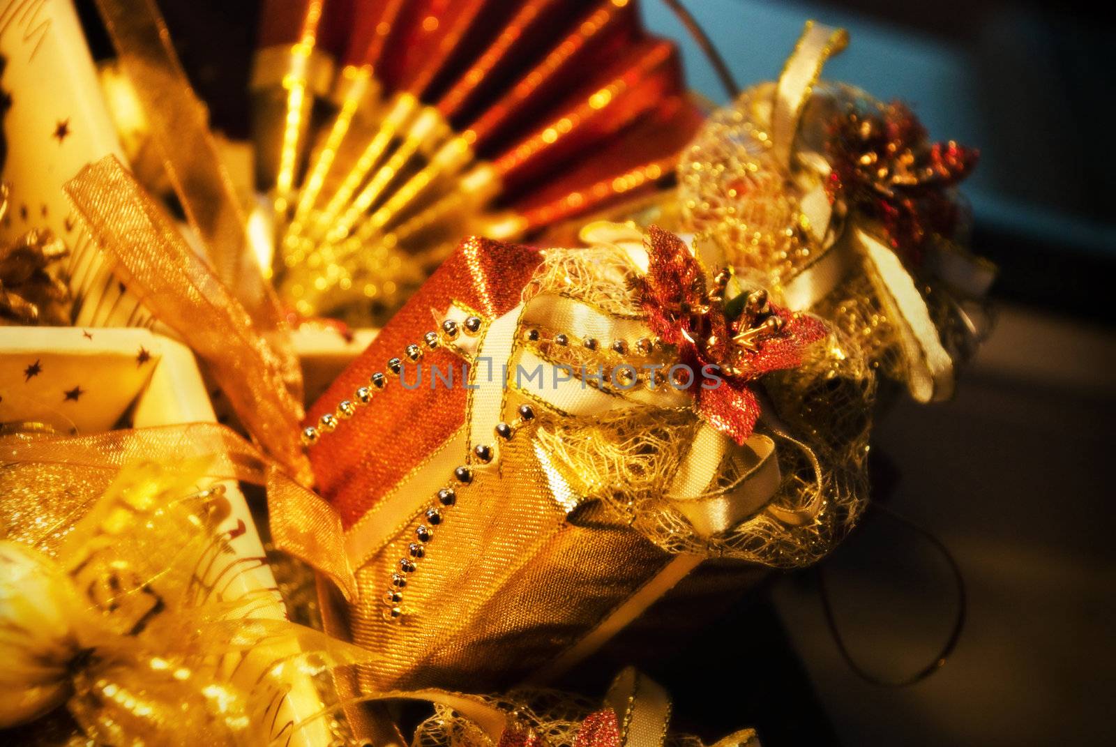 Golden gift boxe with leaf of Mistletoe. Are tied up by tapes with bows

