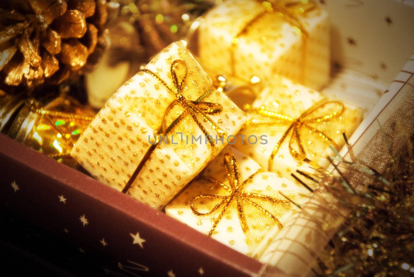 Golden gift boxes on glare background. Are tied up by tapes with bows