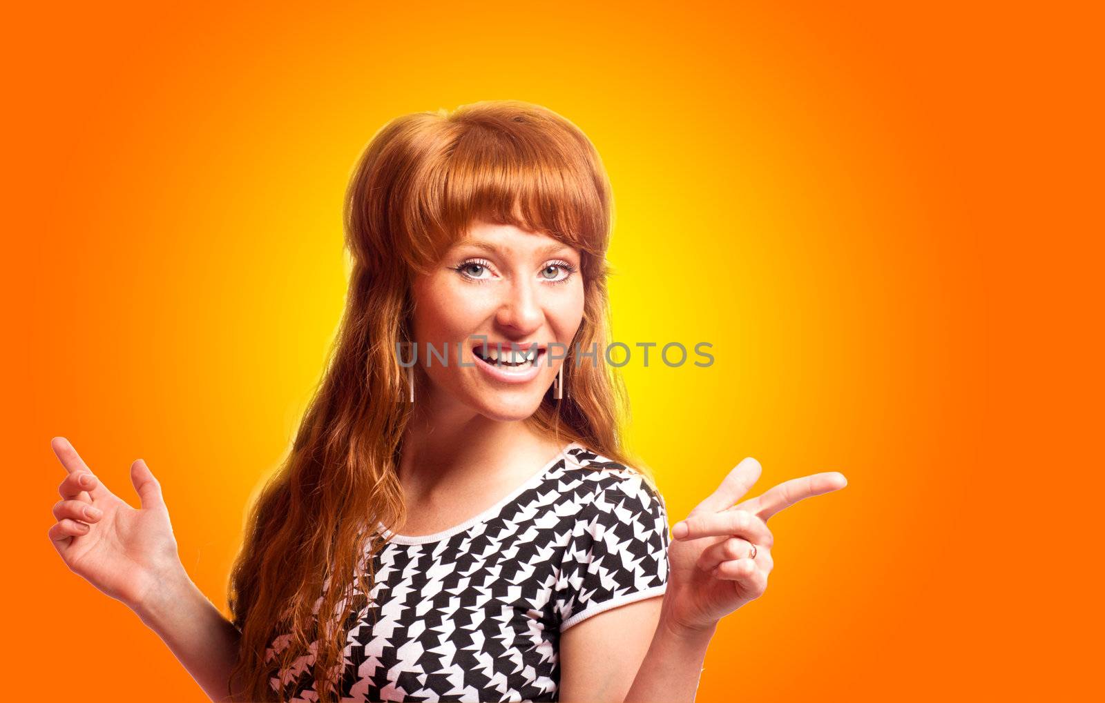 Redhead woman pointing up with smile over orange background