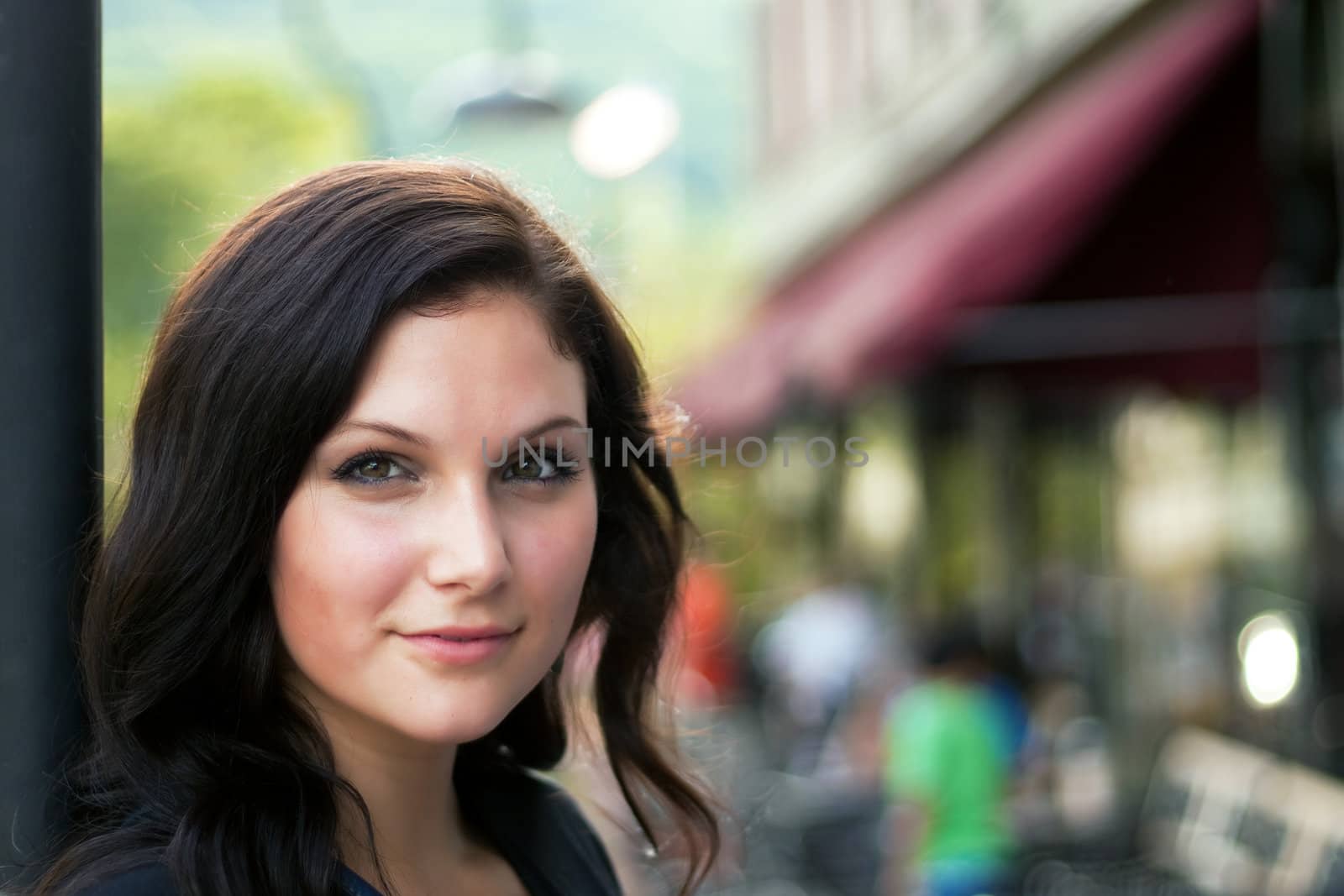 A pretty young brunette woman posing in the city.  Shallow depth of field.