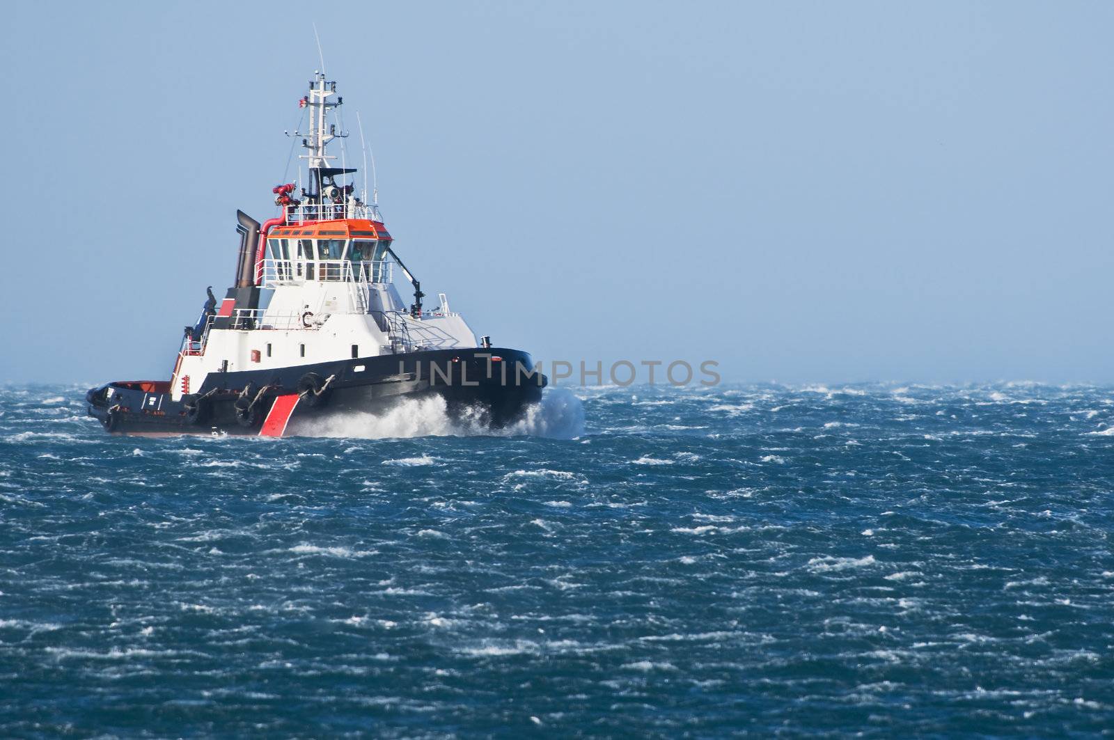 Tug boat navigating in a rough sea