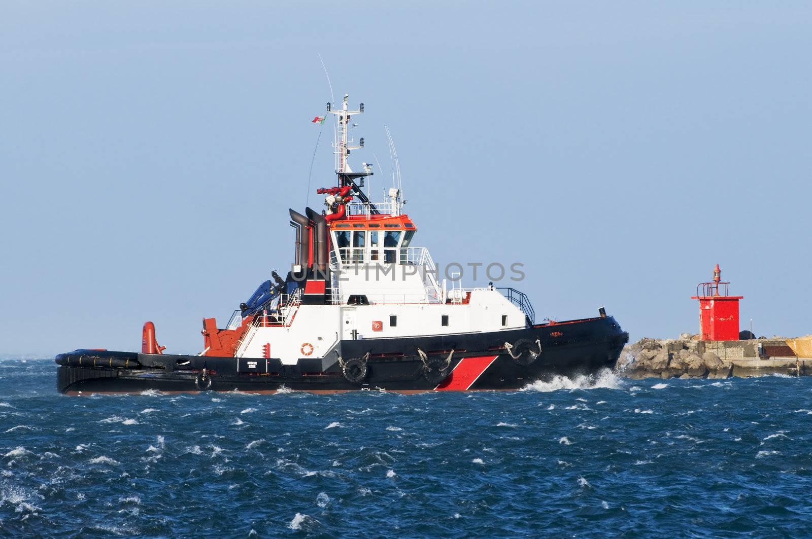 Tug boat navigating in a rough sea